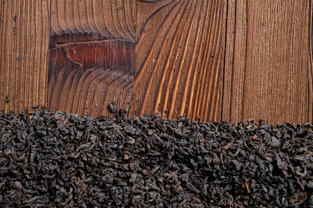 Black tea on a burnt wooden background. Top view. Copy space.