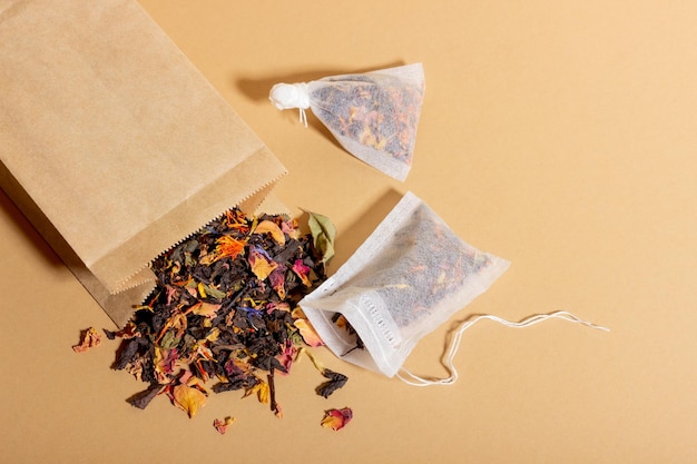 Black tea herbal and fruit brewed in a transparent cup Tea for brewing in tea bags The concept of a natural healthy drink Tea bags on beige background