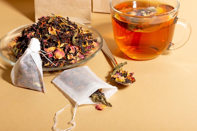 Black tea herbal and fruit brewed in a transparent cup Tea for brewing in tea bags The concept of a natural healthy drink Tea bags on beige background