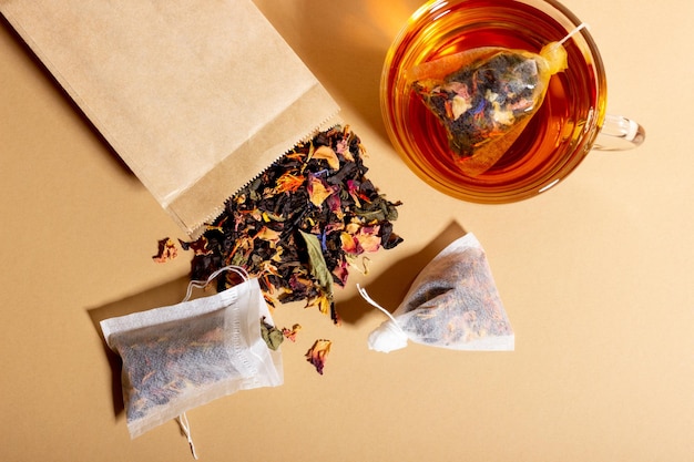 Black tea herbal and fruit brewed in a transparent cup Tea for brewing in tea bags The concept of a natural healthy drink Tea bags on beige background