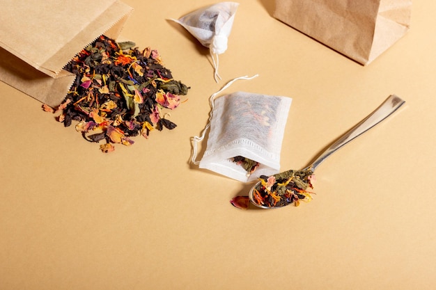 Black tea herbal and fruit brewed in a transparent cup Tea for brewing in tea bags The concept of a natural healthy drink Tea bags on beige background