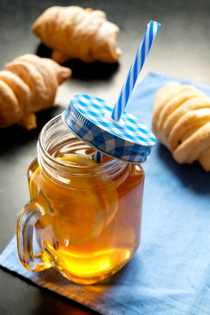 Black tea with lemon in jar cup and biscuits