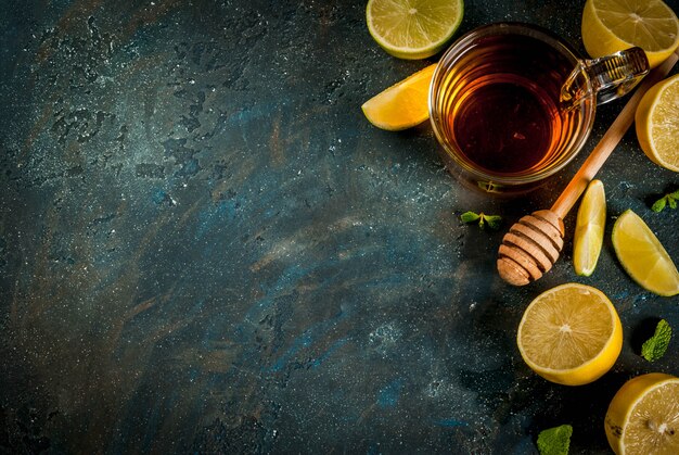 Black tea with lemon and mint on dark blue concrete stone scene top view