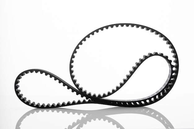 Black timing belt on isolated white wall