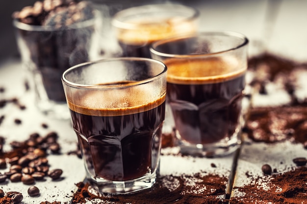 Black Turkish coffee in glass cups and spilled coffee beans.