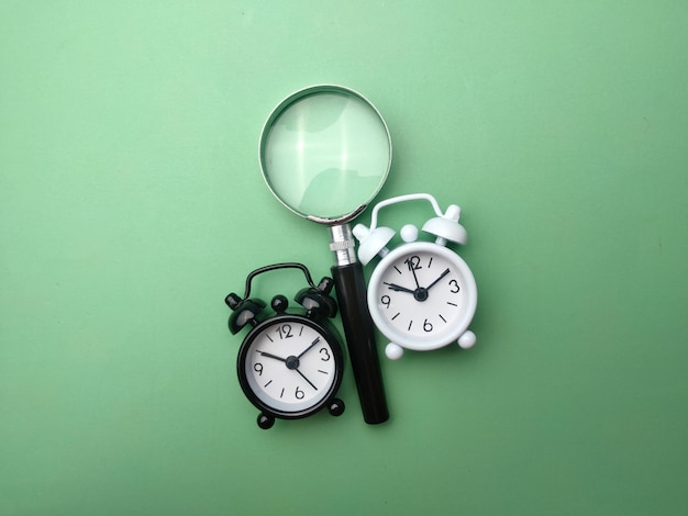 Black and white alarm clock and magnifying glass