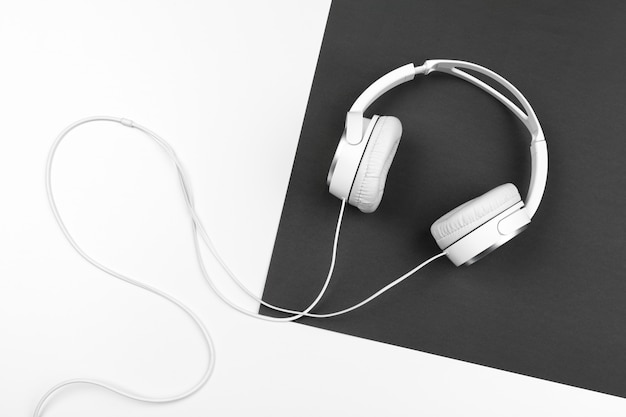 Black and white composition with stylish headphones, flat lay