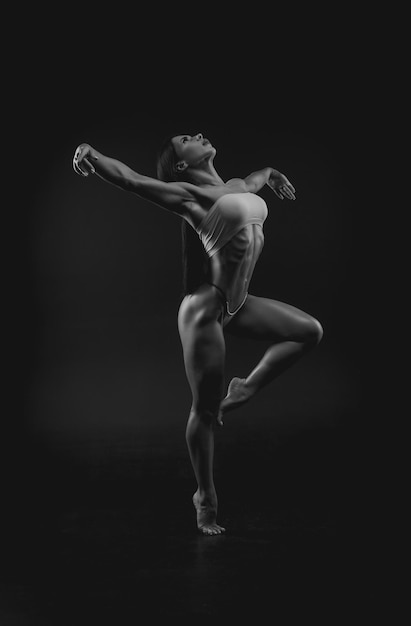 Photo black and white image of a sports woman in the studio beautiful body