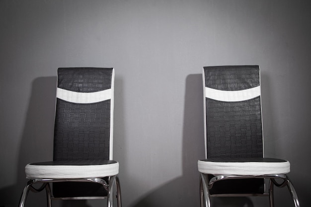 Black and white leather office chairs in grey background