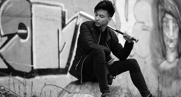 Black White photo of Asian young man outdoors posing at camera