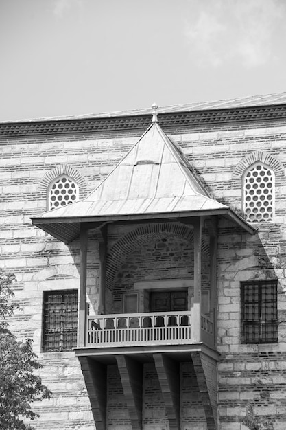 Black and white photo Balcony with conical roof and wooden railings