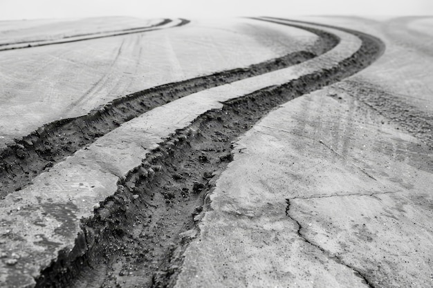 Photo black and white photo of a road in a desolate area with zigzagging skid marks from sudden stops zigzagging skid marks from sudden stops