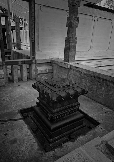 A black and white photo of a temple with a carved design on the top.