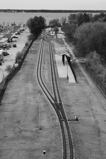 Photo a black and white photo of a train track with a train going through it