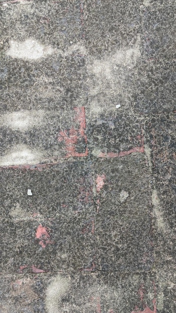 A black and white photo of a wall with a red cross in the middle.