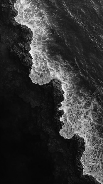 a black and white photo of a wave breaking on the surface