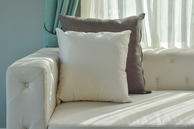 Black and white pillow on beige sofa with natural light in the living room