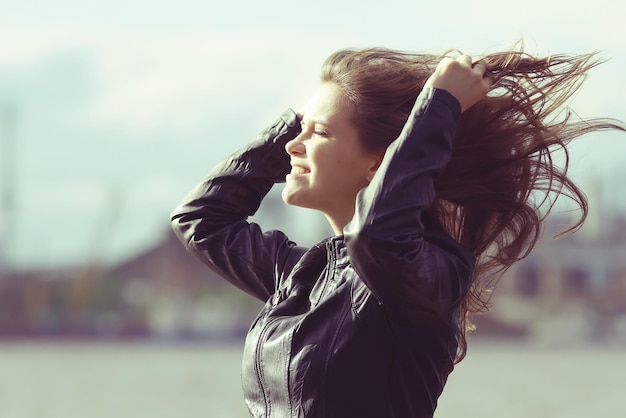 Black and white portrait of an adult girl in windy weather