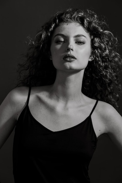 Black and white portrait of a beautiful young woman looking straight at the camera.