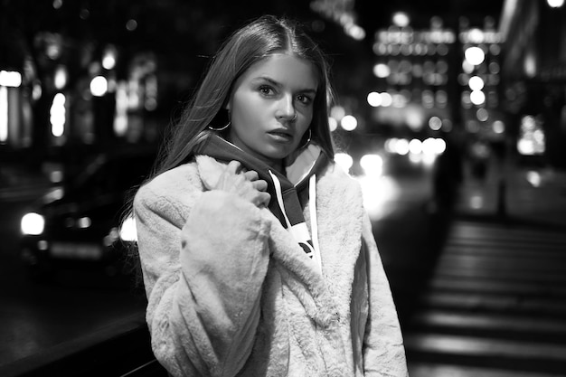 Black and white portrait of a girl against the background of a night city