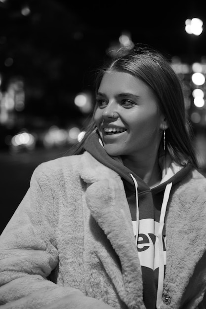 Black and white portrait of a girl against the background of a night city