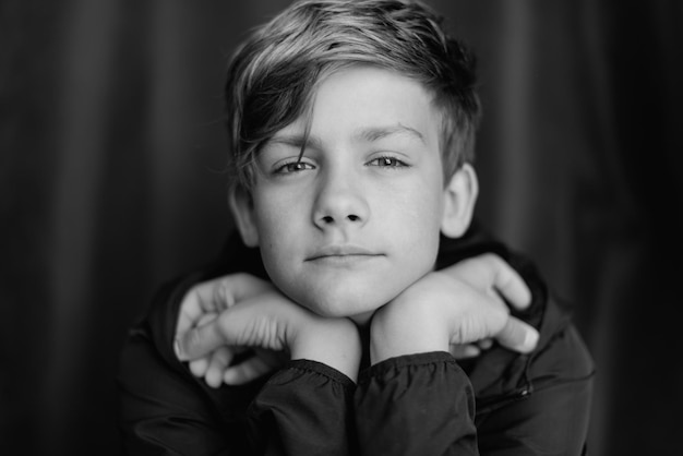 Black and white portrait of teenage boy on dark background Low key close up shot of a young teen boy Black and white photography Selective focus