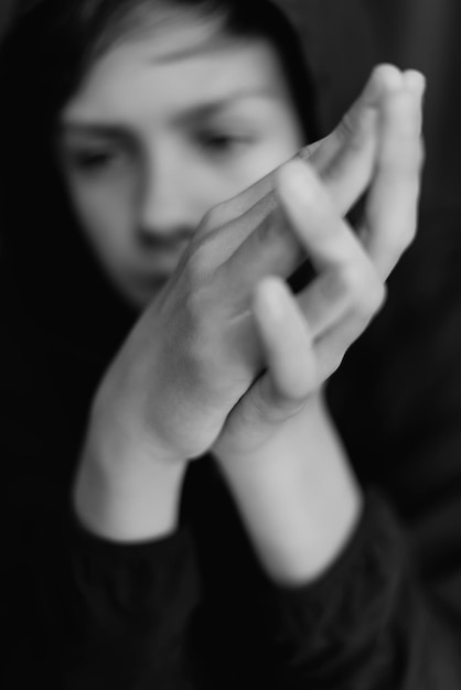 Black and white portrait of teenage boy on dark background Low key close up shot of a young teen boy Black and white photography Selective focus