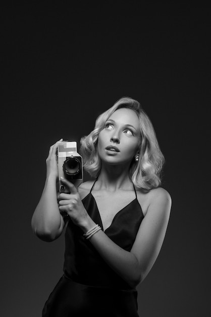 Black and white portrait of woman with camera in old hollywood glamour style