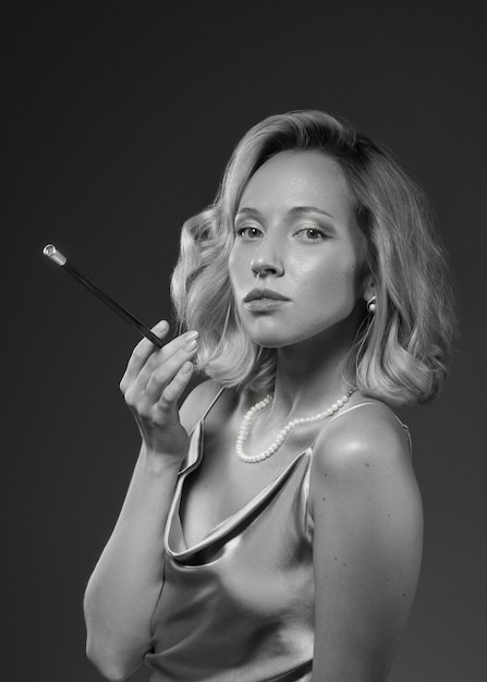 Black and white portrait of woman with cigarette in old hollywood glamour style