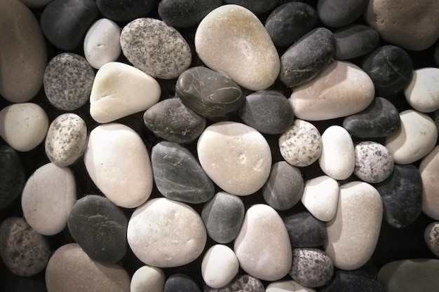 Black and white sea pebbles abstract background with vignetting