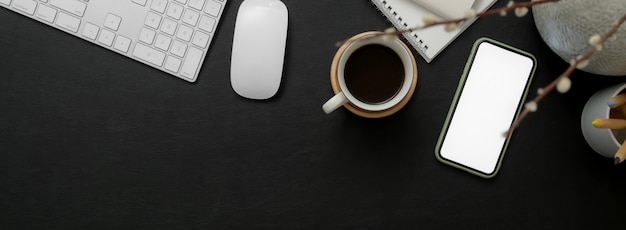 Black and white workspace with smartphone, computer device, coffee cup, notebook and copy space