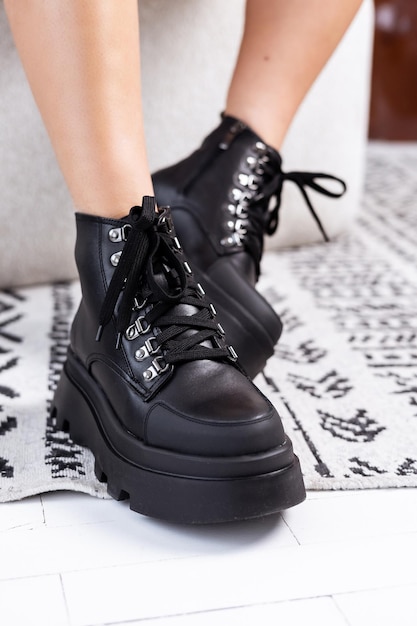 Black winter women's boots made of genuine leather with laces close-up. High quality stylish women's shoes