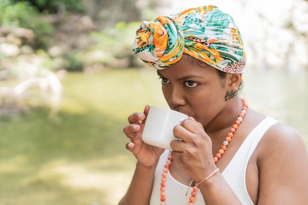 Black Woman enjoying morning coffee by the river