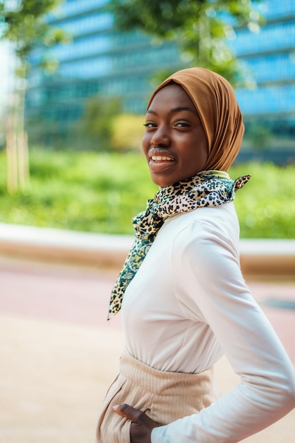 Black woman in hijab and scarf standing on street