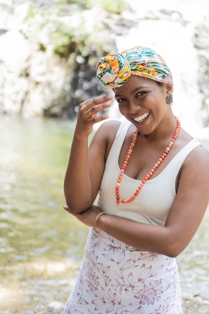 Black woman poses confidently wearing colorful headscarf