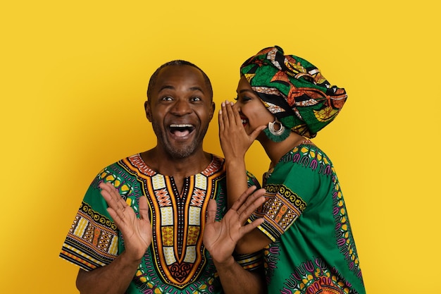 Black woman sharing secrets with husband african couple on yellow