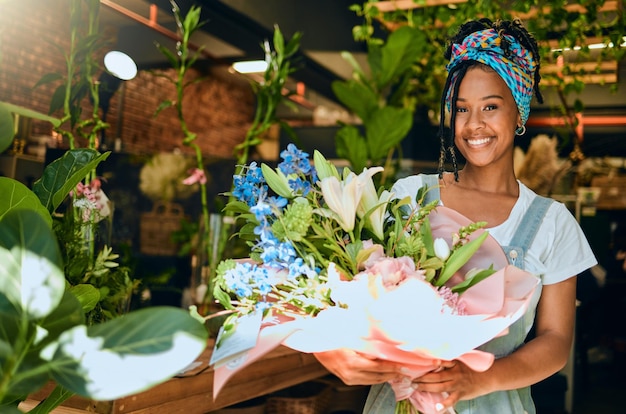 Black woman with bouquet flowers and florist in greenhouse small business owner and smile in portrait Happiness nature and entrepreneur with floral arrangement Spring and vision with leadership