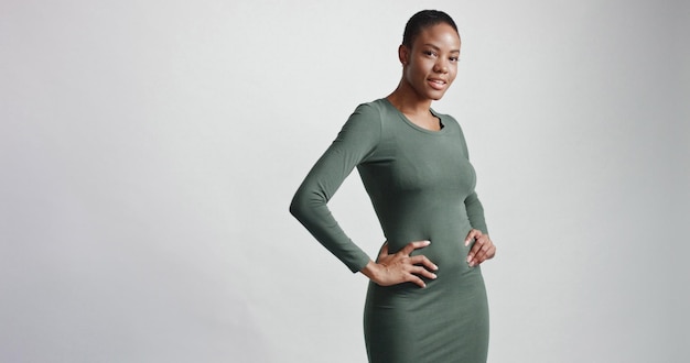 Black woman with a short haircut in studio shootsmiling and wearing dress