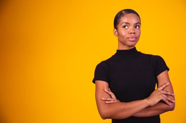 Black woman on yellow background with arms crossed. business woman on yellow background