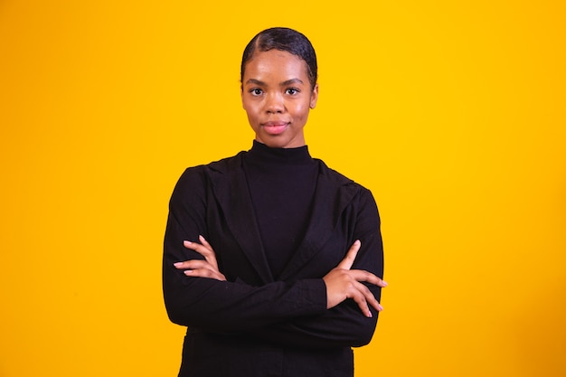 Black woman on yellow background with arms crossed. business woman on yellow background