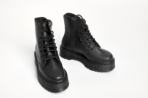 Black women combat boots on high heel platform with lug soles on isolated white background