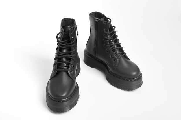 Black women combat boots on high heel platform with lug soles on isolated white background