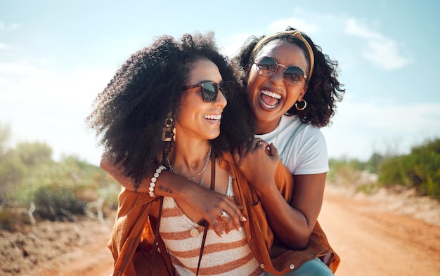 Black women friends and nature holiday portrait vacation or summer trip Safari sunglasses and girls piggy back spending time together bonding and having fun in countryside outdoors or desert