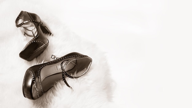 Black women high heel shoes on a white furry rug on a white background with copy space