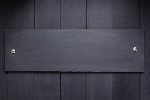 Black wooden background as texture surface with screws