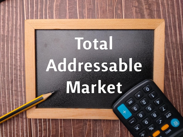 Black wooden board and pencil with the word Total Addressable Market