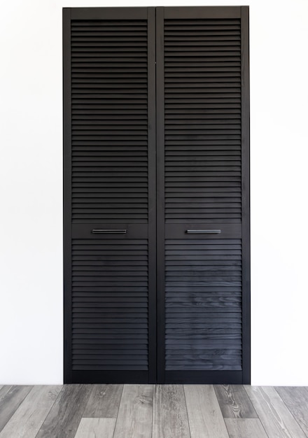 Black wooden wardrobe decorated with blinds, wardrobe with blinds decoration.