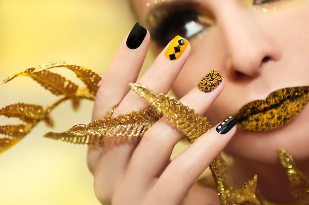 Black and yellow manicure with rhinestones and makeup