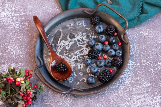 Blackberries and blueberries on a metal platter Summer harvest of cranberries