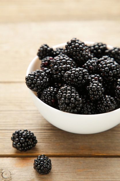 Blackberries in a bowl on wooden table